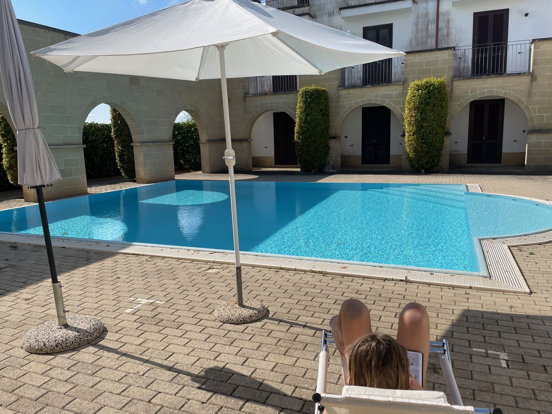 Piscina condivisa con lettini e ombrelloni